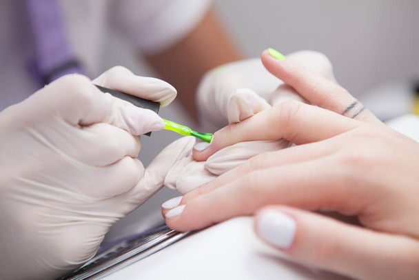 Close up of manicurist doing neon nails - Photo, Image