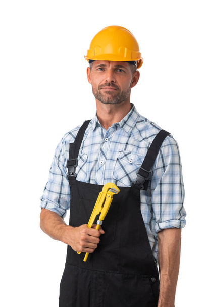 Portrait of confident male repairman contractor worker in coveralls holding adjustable spanner isolated on white background - Zdjęcie, obraz