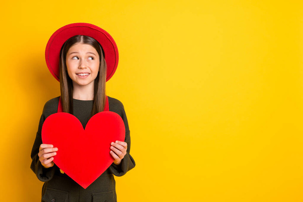 Photo portrait of lovely girl keeping red heart shaped postcard looking copyspace isolated vibrant yellow color background - Foto, imagen