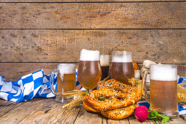 Oktoberfest sfondo cibo, menu tradizionale bavarese vacanza cibo, salsicce con pretzel, crauti, bicchieri di birra e tazze su legno sole illuminato spazio copia di sfondo - Foto, immagini