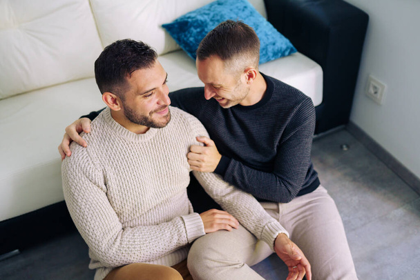 gay casal sentado perto o sofá no casa no um romântico momento - Foto, Imagem