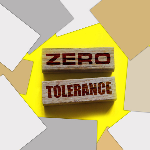 Tolleranza zero parole da blocchi di legno con lettere, punendo severamente ogni comportamento inaccettabile, concetto di tolleranza zero, sfondo giallo - Foto, immagini
