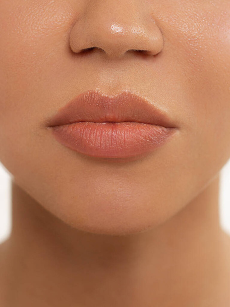 Sexual full lips. Natural gloss of lips and woman's skin. The mouth is closed. Increase in lips, cosmetology. Pink lips and long neck. - 写真・画像