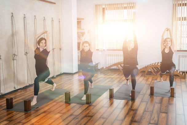Grupa młodych sportowców ćwiczących jogę, pozujących, ćwiczących w pomieszczeniach, lekcji jogi w klubie lub studio - Zdjęcie, obraz