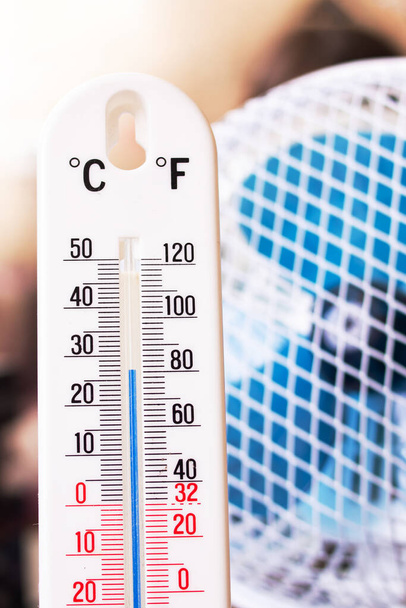 Маленький вентилятор и комнатный ртутный термометр вблизи - Фото, изображение