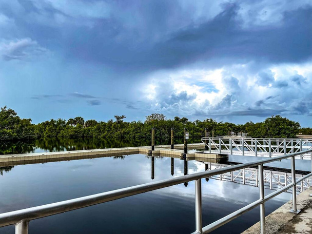 Nubes de tormenta que se reflejan en las tranquilas aguas del puerto deportivo del Parque Estatal Collier-Seminole, cerca del muelle flotante. - Foto, Imagen