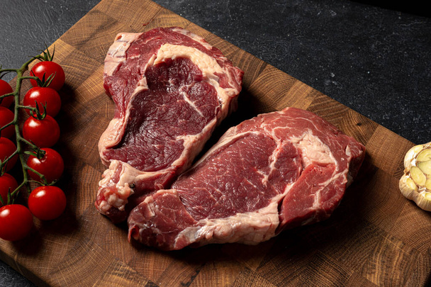Raw marbled beef steak on a wooden cutting board - Fotó, kép