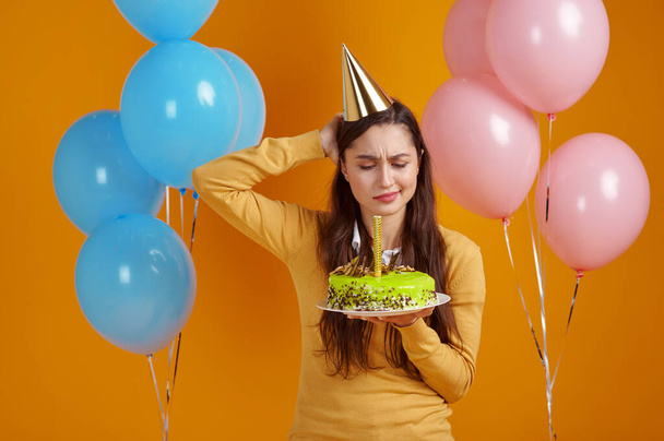Jolie femme tenant gâteau d'anniversaire avec feu d'artifice - Photo, image