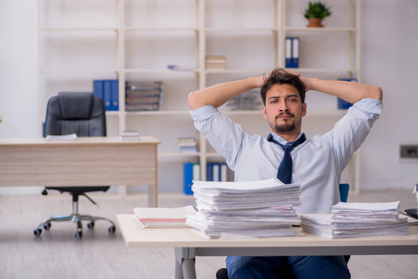 Young male employee unhappy with excessive work in the office - Photo, Image