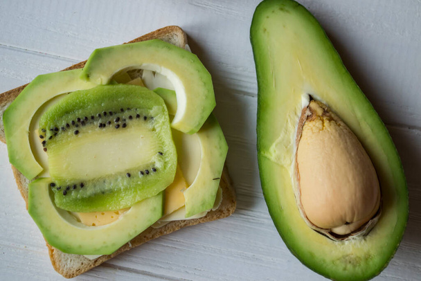 The sandwiches with avocado and kiwi on a white wooden background. - Foto, immagini