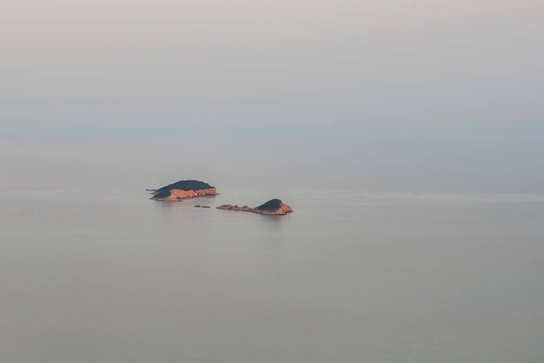 アドリア海の真ん中に浮かぶ島。青い水。日没. - 写真・画像