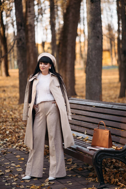 Picture of beautiful woman goes for a walk to the autumn park - Photo, Image