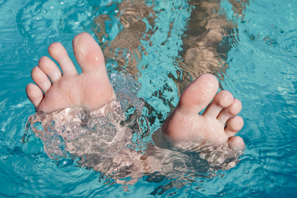 Toes peeking out of the water. Foot with the pool background. Toes close up - Foto, Imagen