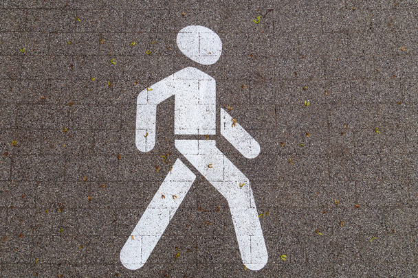 Markering op plavuizen in de vorm van een abstracte man. Voetgangersgebied op de gecombineerde stoep met een fietspad. Abstracte achtergrond - Foto, afbeelding
