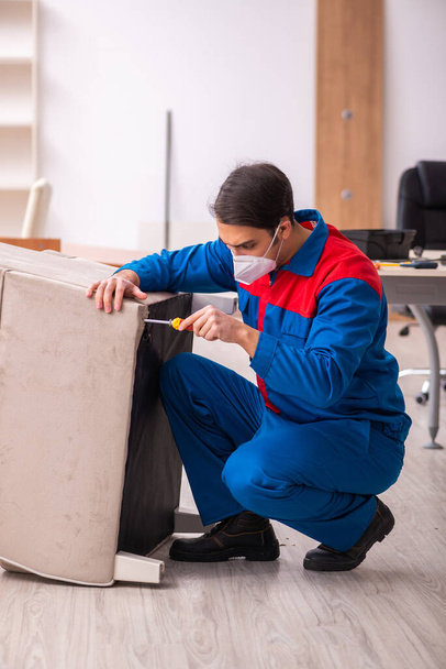 Joven carpintero masculino trabajando en la oficina durante una pandemia - Foto, Imagen