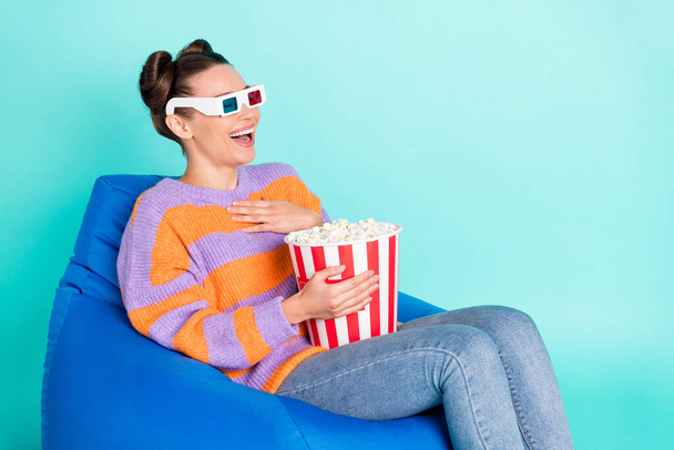Portrait of attractive amazed cheerful girl sitting in chair watching funny film having fun isolated over bright teal turquoise color background - Foto, Imagem