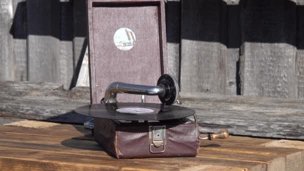 Antiguo fonógrafo de gramófono marrón pequeño al aire libre. disco de vinilo girando. de cerca - Metraje, vídeo