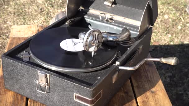 Oude grote zwarte grammofoon fonograaf buiten. de vinyl plaat draait. close-up - Video