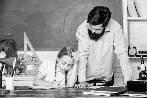 Private lesson. Doing hometask paperwork. Tired kid unmotivated study learn. Homeschooling with father. Pedagogue skills. School teacher and schoolgirl. Man bearded pedagogue. Strict pedagogue - Foto, imagen