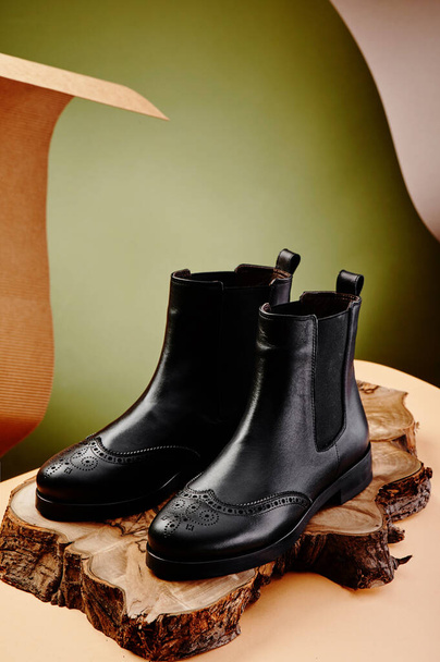 Черные кожаные сапоги из натуральной кожи в классическом стиле на деревянном крючке. Крупный план - Фото, изображение