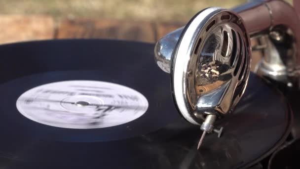 Antiguo fonógrafo de gramófono marrón pequeño al aire libre. disco de vinilo girando. de cerca - Metraje, vídeo
