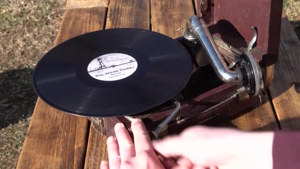 男の手はレコード音楽を再生するために蓄音機機構をオンにします。閉めて  - 映像、動画