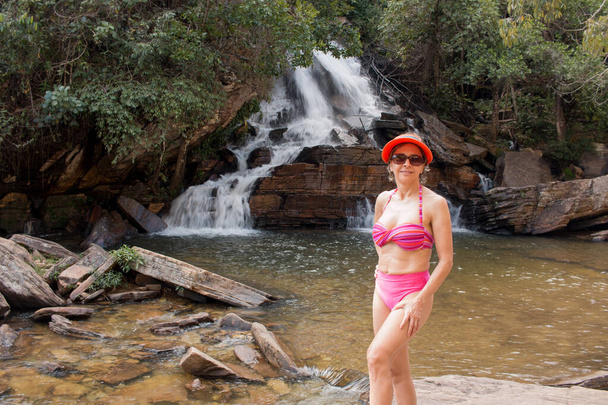 Mujer Madura feliz disfrutando frente a una pequeña cascada llamada Usian Falls en el interior de Brasil - Foto, Imagen