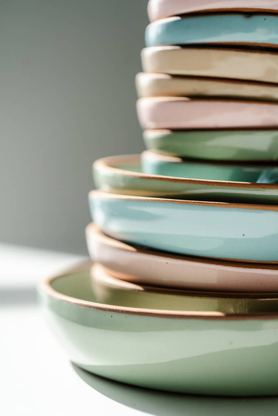 A large stack of ceramic cups in pastel colors. - Zdjęcie, obraz