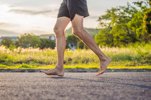 A man runner is engaged in jogging on the asphalt without shoes, without sneakers, for health - Foto, Imagem