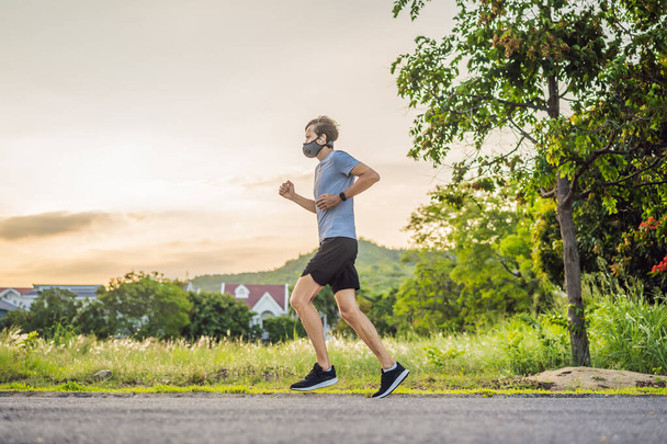 Runner wearing medical mask, Coronavirus pandemic Covid-19. Sport, Active life in quarantine surgical sterilizing face mask protection. Outdoor run on athletics track in Corona Outbreak - Foto, Imagem
