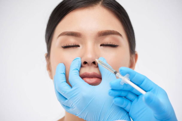Frau bekommt nicht-chirurgische Nasenkorrektur - Foto, Bild