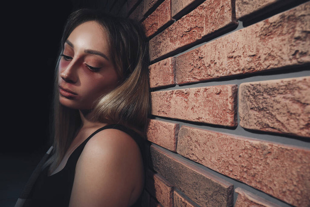 Overdosed drug addicted woman near brick wall. Space for text - Foto, immagini