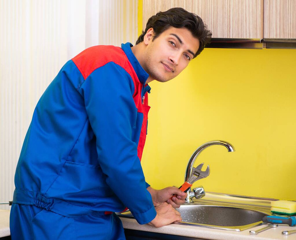 Plumber repairing tap at kitchen - Photo, Image
