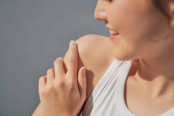 Young skin care woman applying body lotion on arm and shoulder at home - Photo, Image