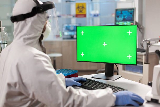 Scientist man wearing protection suit typing on computer - Φωτογραφία, εικόνα