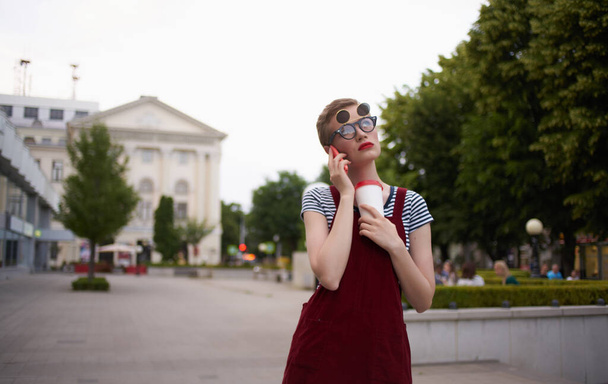 mujer con una taza de bebida con gafas al aire libre caminar aire libre - Foto, imagen