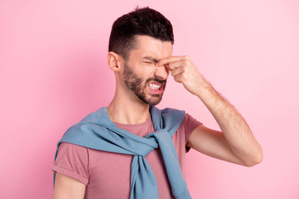 Photo of unhappy upset sad handsome man suffering headache migraine cover eyes isolated on pink color background - Foto, immagini