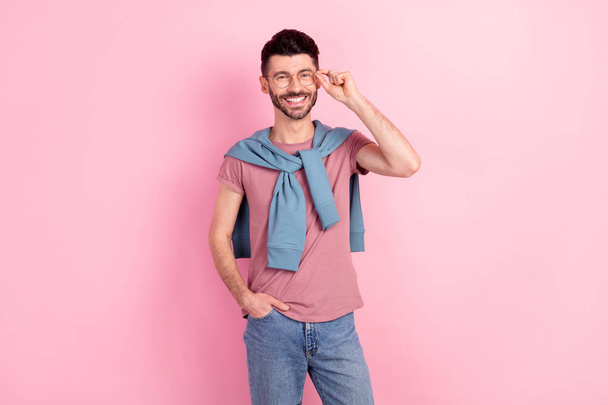 Photo of attractive cheerful young man hold hand pocket jeans wear glasses good mood isolated on pink color background - Foto, Bild