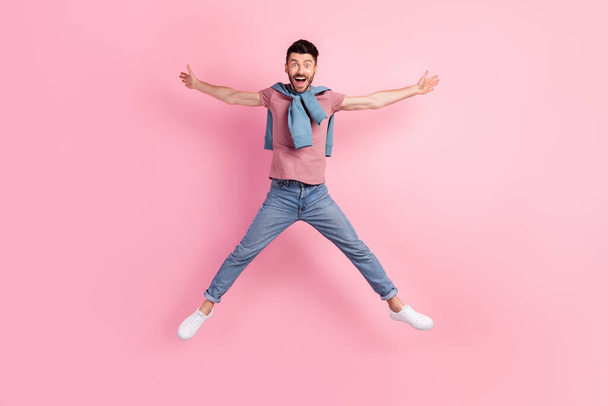Full length photo of active cheerful young gut jump up star shape isolated on pink pastel color background - Foto, imagen