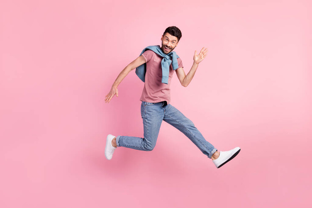 Full size photo of happy cheerful smiling handsome man running in air say hello isolated on pink color background - 写真・画像
