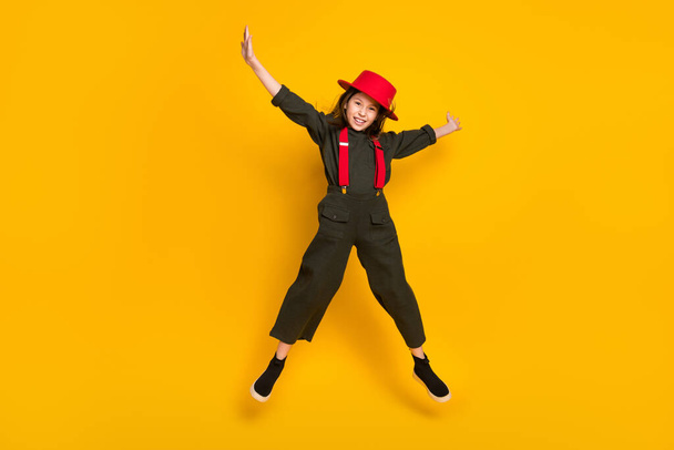 Full length body size view of pretty cheerful girl jumping wearing khaki clothes good mood isolated over bright yellow color background - Zdjęcie, obraz