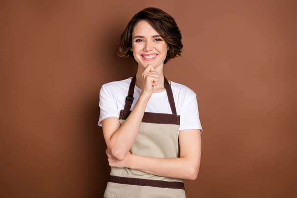 Photo of pretty cheerful person arm finger on chin look camera have good mood isolated on brown color background - Fotó, kép