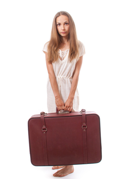 woman lifts a heavy suitcase, isolated on white - Foto, afbeelding