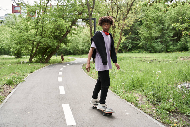 Man practicing skateboarding while resting at the green park at his city - Foto, Imagem