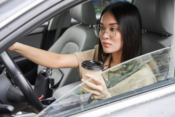 Woman riding at the car and looking at the road while drinking coffee during driving - Foto, Imagem