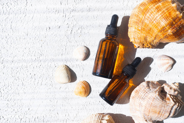 Cosmetic oil and shells . The concept of a bottle of cosmetic oil without a name. Cosmetology. Skin care. Spa - Foto, afbeelding