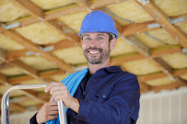 a happy builder holding pipes - Фото, зображення