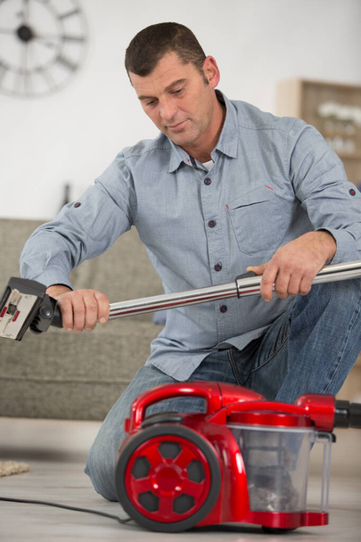 handsome repairman fixing vacuum cleaner - Photo, image
