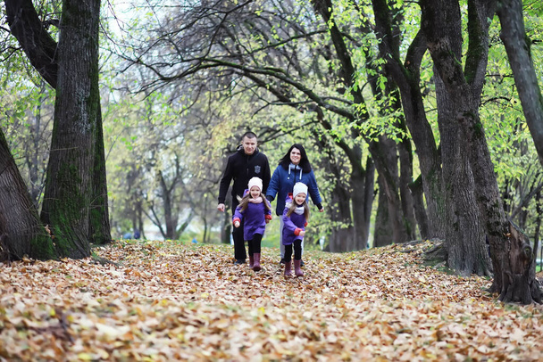 Bambini per una passeggiata nel parco autunnale. Caduta di foglie nel parco. Famiglia. Caduta. Felicità. - Foto, immagini