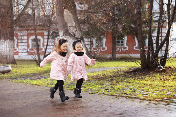 Young family on a walk in the autumn park on sunny day. Happiness to be together. - Photo, Image